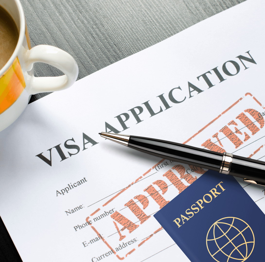An approved visa application form with a passport and a pen on a desk, accompanied by a cup of coffee.