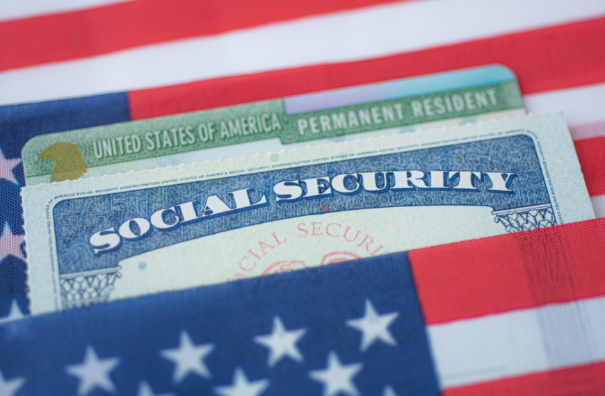 Social Security and Green Card nestled under the United States Flag.