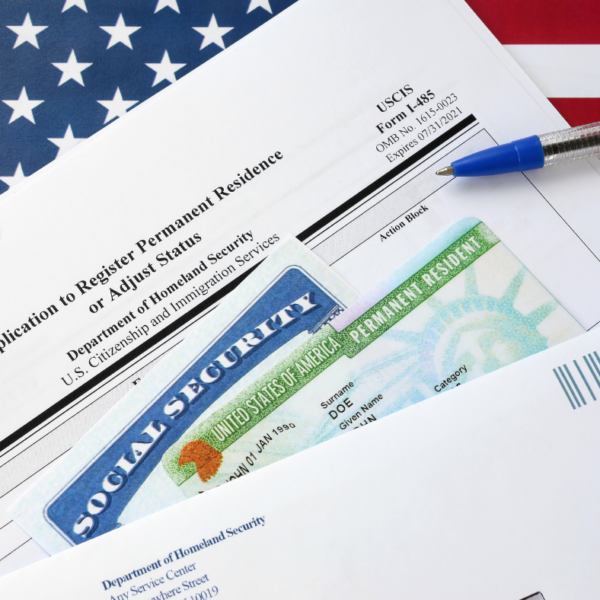EB5 Visa: Social Security card and Green Card on an I-485 form application, with a portion of the United States flag in the corner.